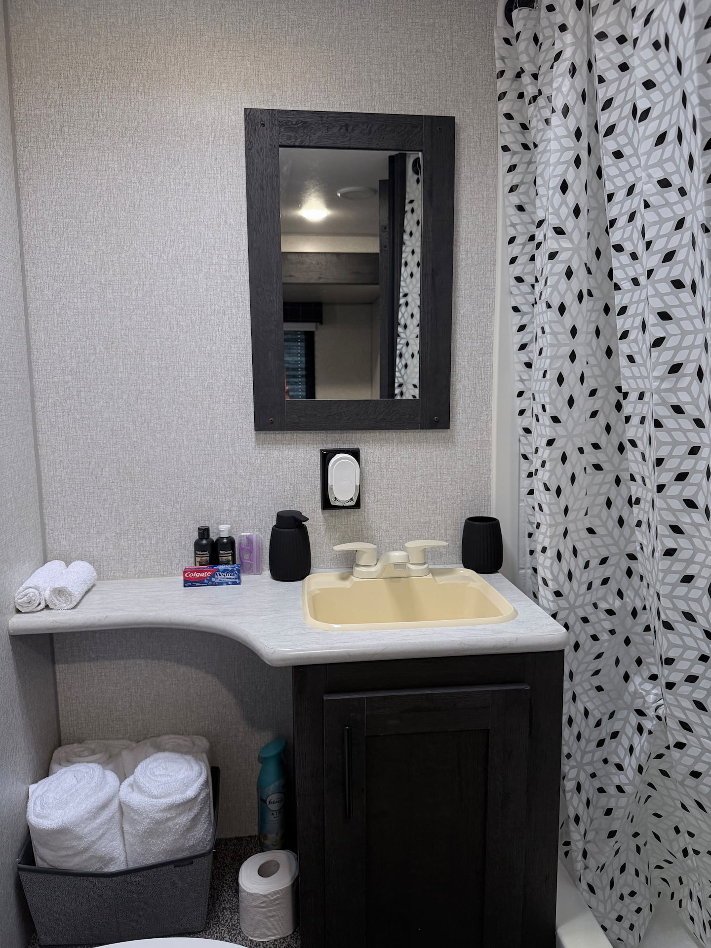 Baño con lavamanos, espejo y toallas